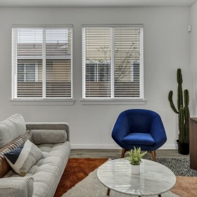 furnished living room with a beige sofa and blue chair  furnished living room with a beige sofa and blue chair